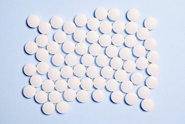 Rybelsus medication in white pills arranged in a circle on a blue background.