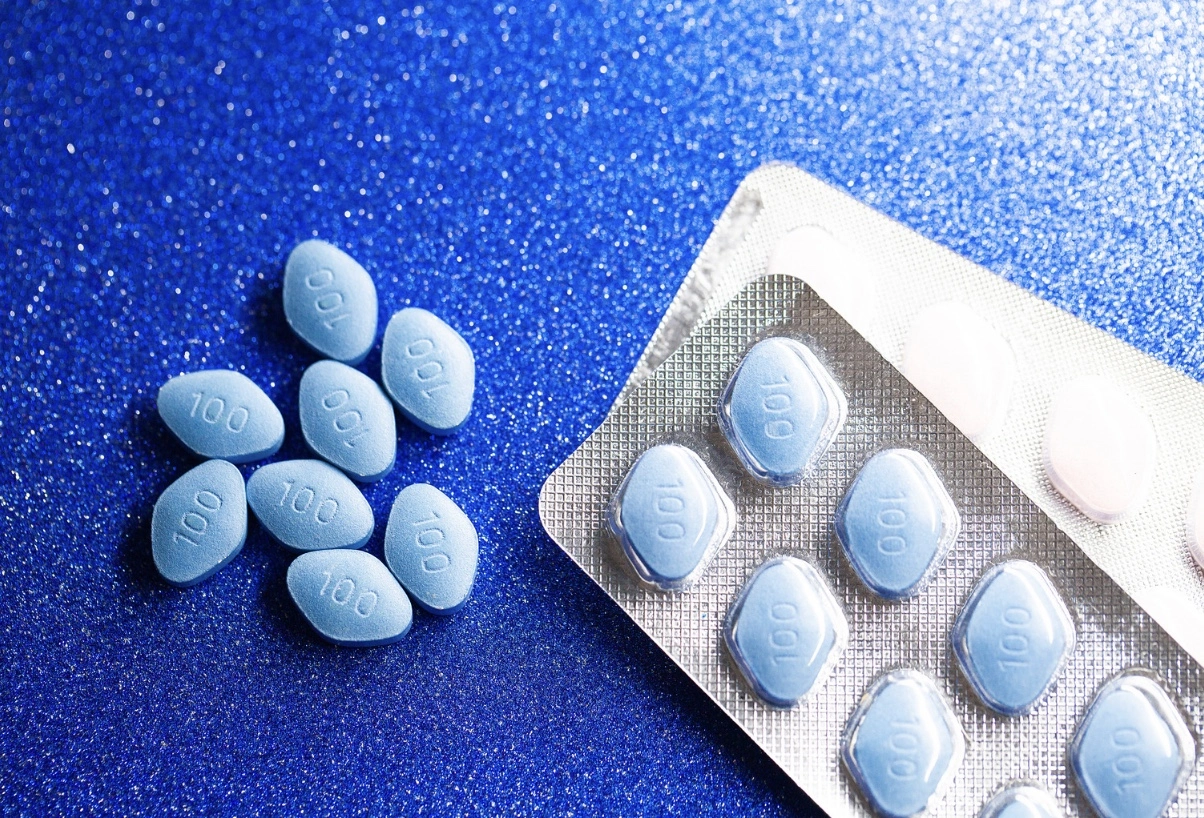 A pack of viagra pills on a blue surface.