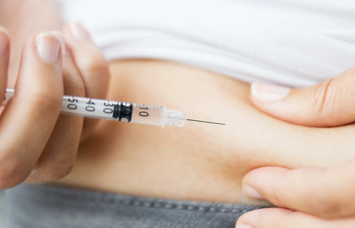 A woman experiencing insulin therapy for diabetes via syringe injection.