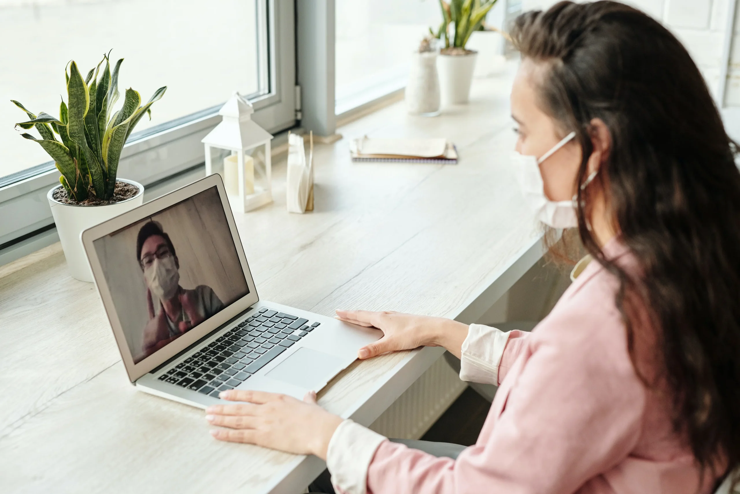 A woman is using a laptop to make a video call and learn more about telemedicine.